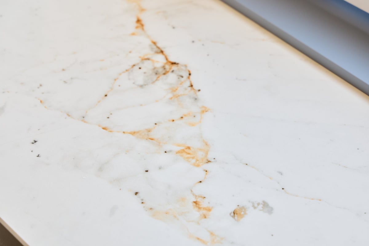 Closeup of marble surface with etching and dull spots from acid damage