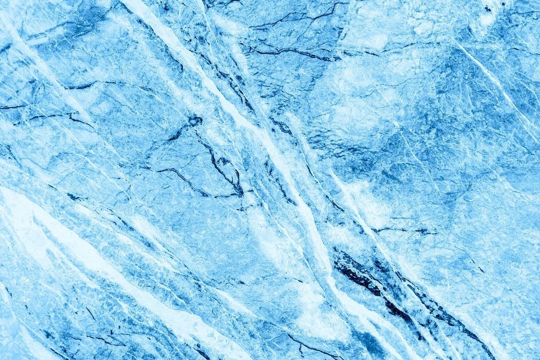 Close-up of ice surface with diagonal cracks and crevasses in shades of blue and white