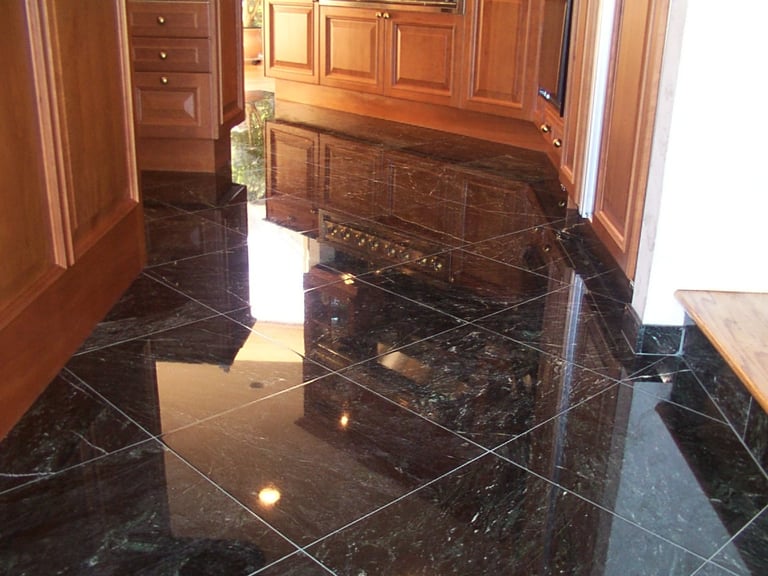 Polished black marble kitchen floor showcasing true stone restoration